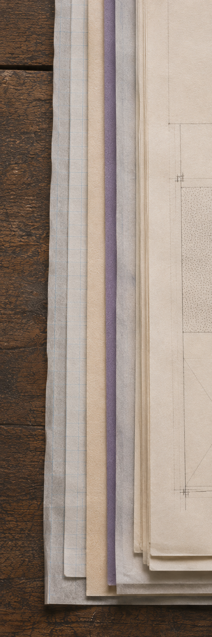 Layered website plans and textured papers on a timber table
